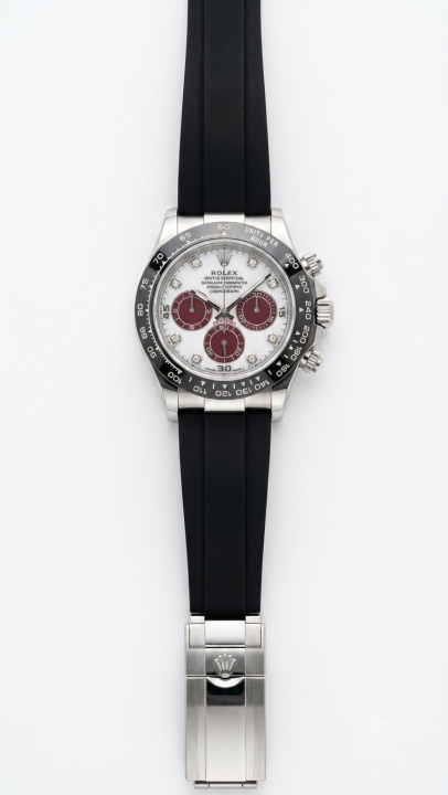 Roleex Cosmograph Daytona chronograph white-and-red dial paired with a black rubber strap